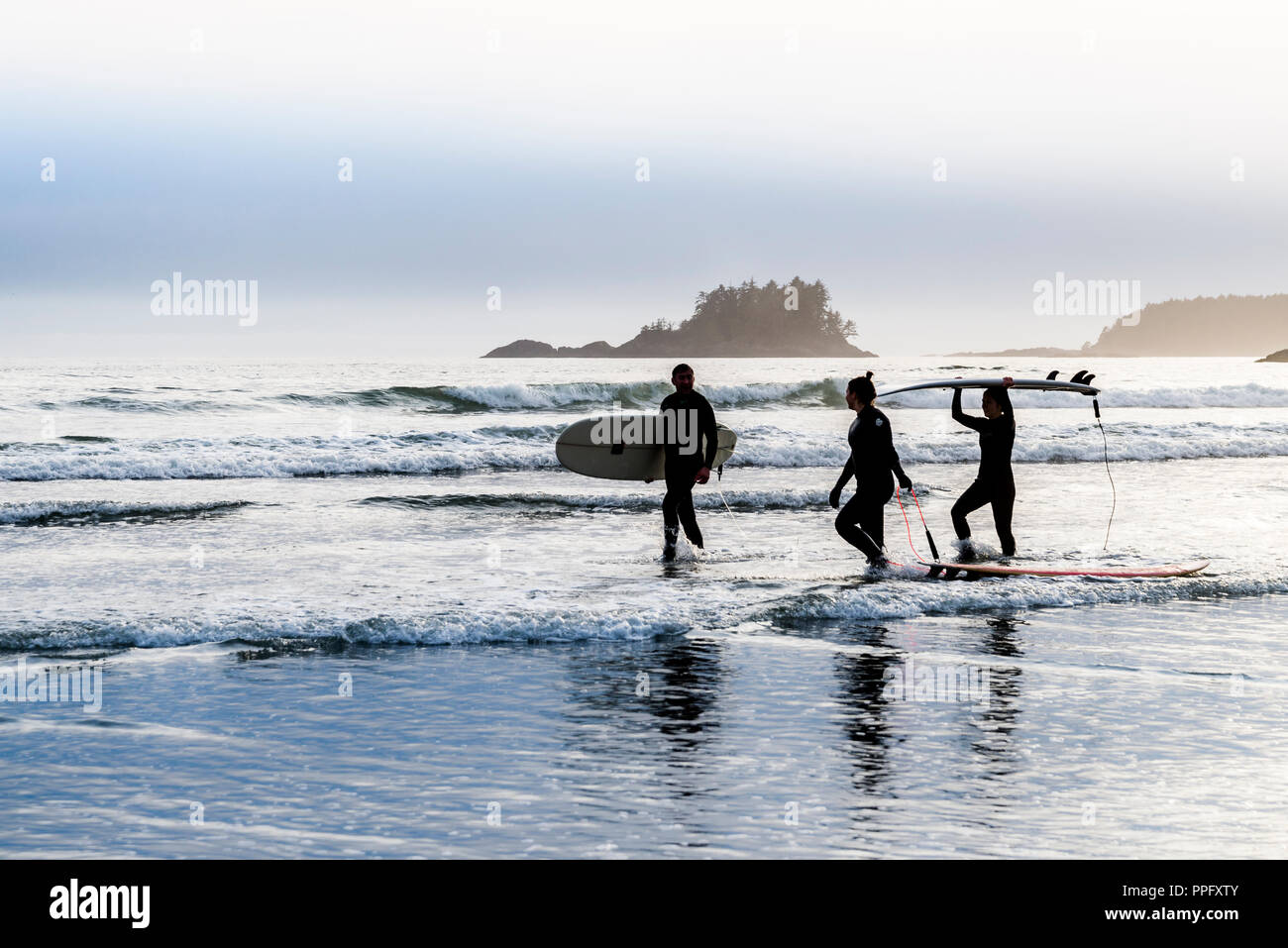 I surfisti a piedi a shoeline, Chesterman Beach, Tofino, British Columbia, Canada Foto Stock