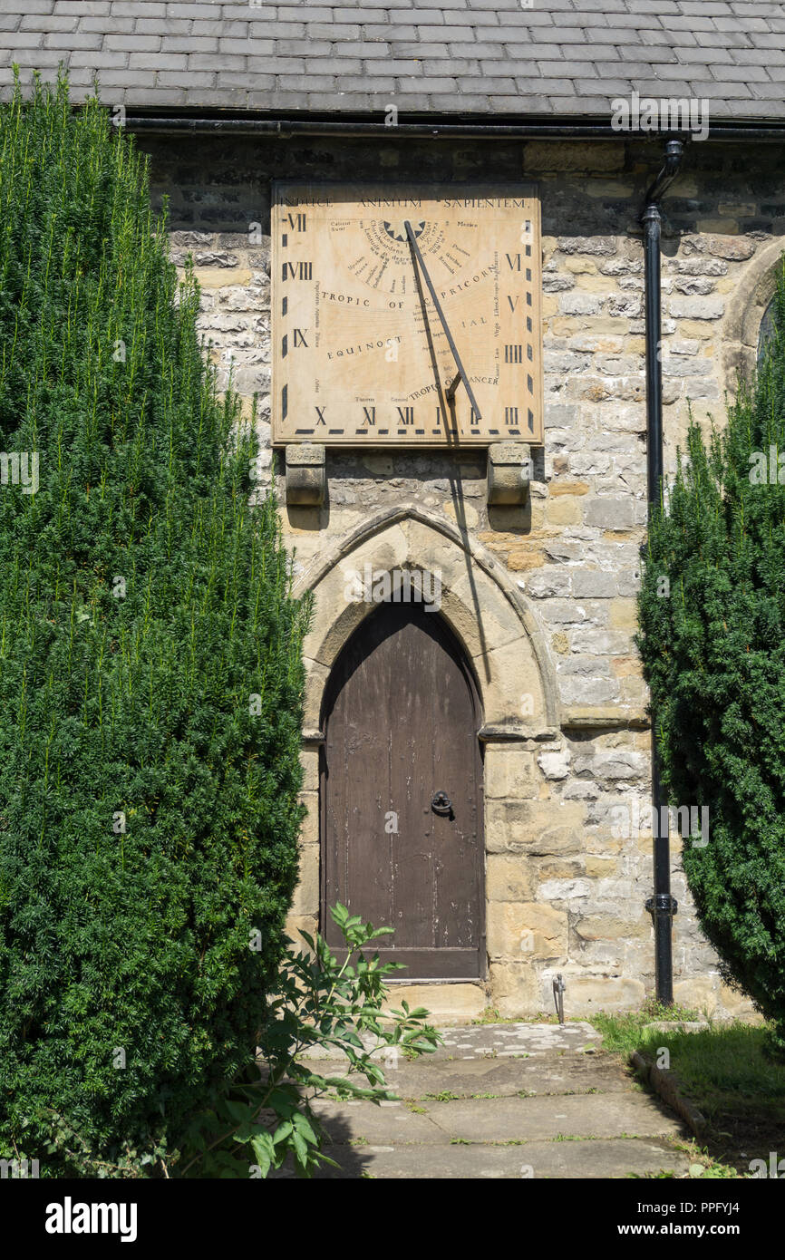 Montato a parete del xviii secolo meridiana al di sopra di un ingresso alla chiesa di San Lorenzo, Eyam, Derbyshire, Regno Unito Foto Stock