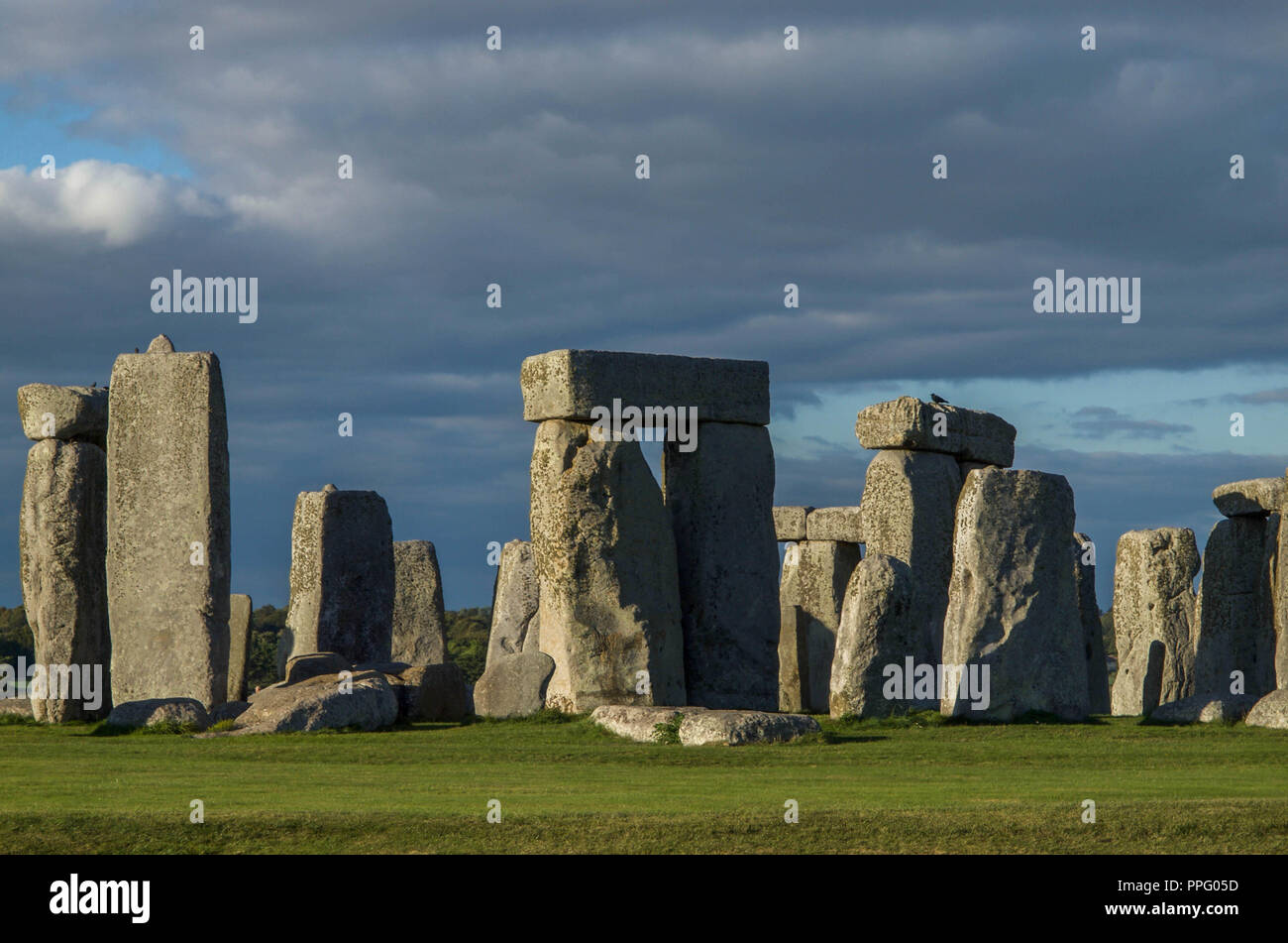 Il sito di Stonehenge nel tardo pomeriggio di sole con nuvole di oscuramento Foto Stock