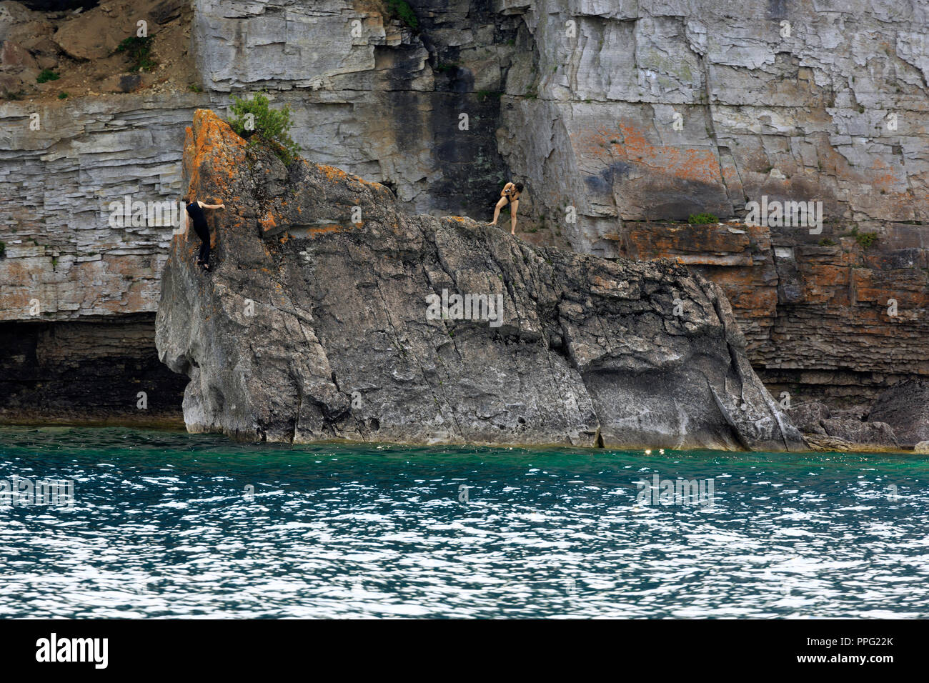 Donne salire sulle rocce sulla riva della penisola di Bruce, Georgian Bay, Ontario Foto Stock