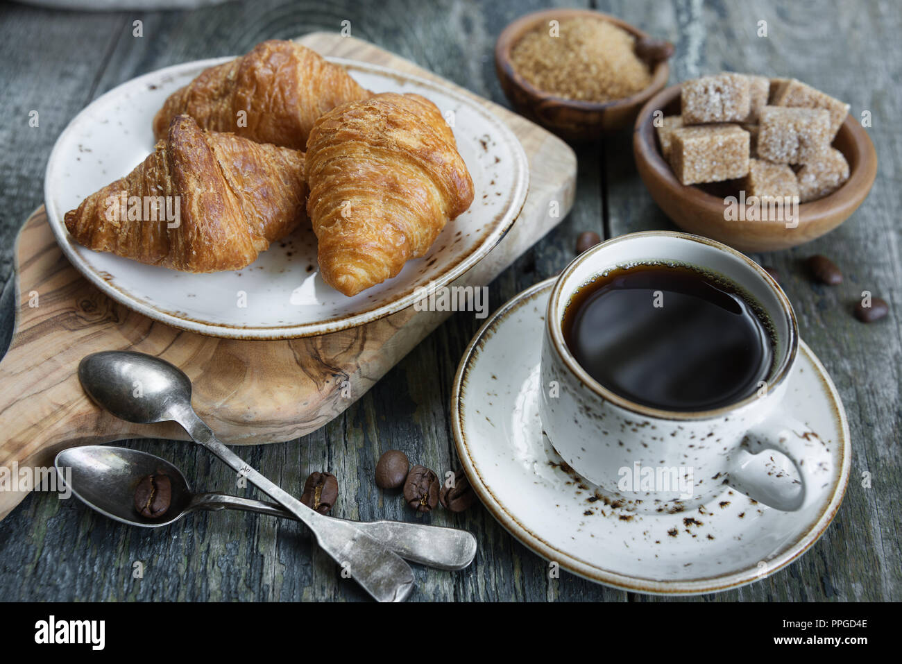 Colazione Leggera costituito da una tazza di caffè nero e croissant Foto Stock