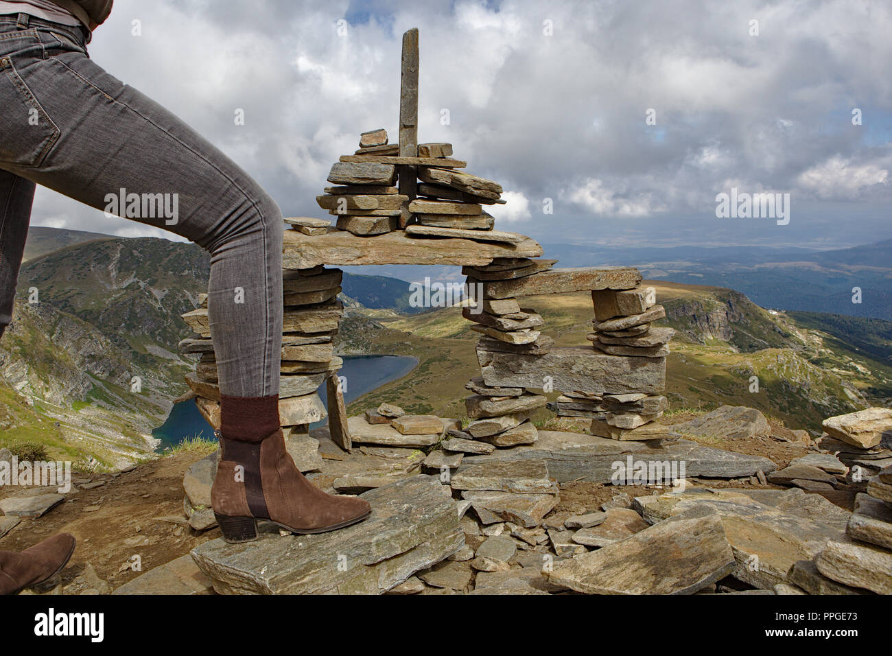 Gambe femmina in jeans e scarpe alla cima della montagna Foto Stock