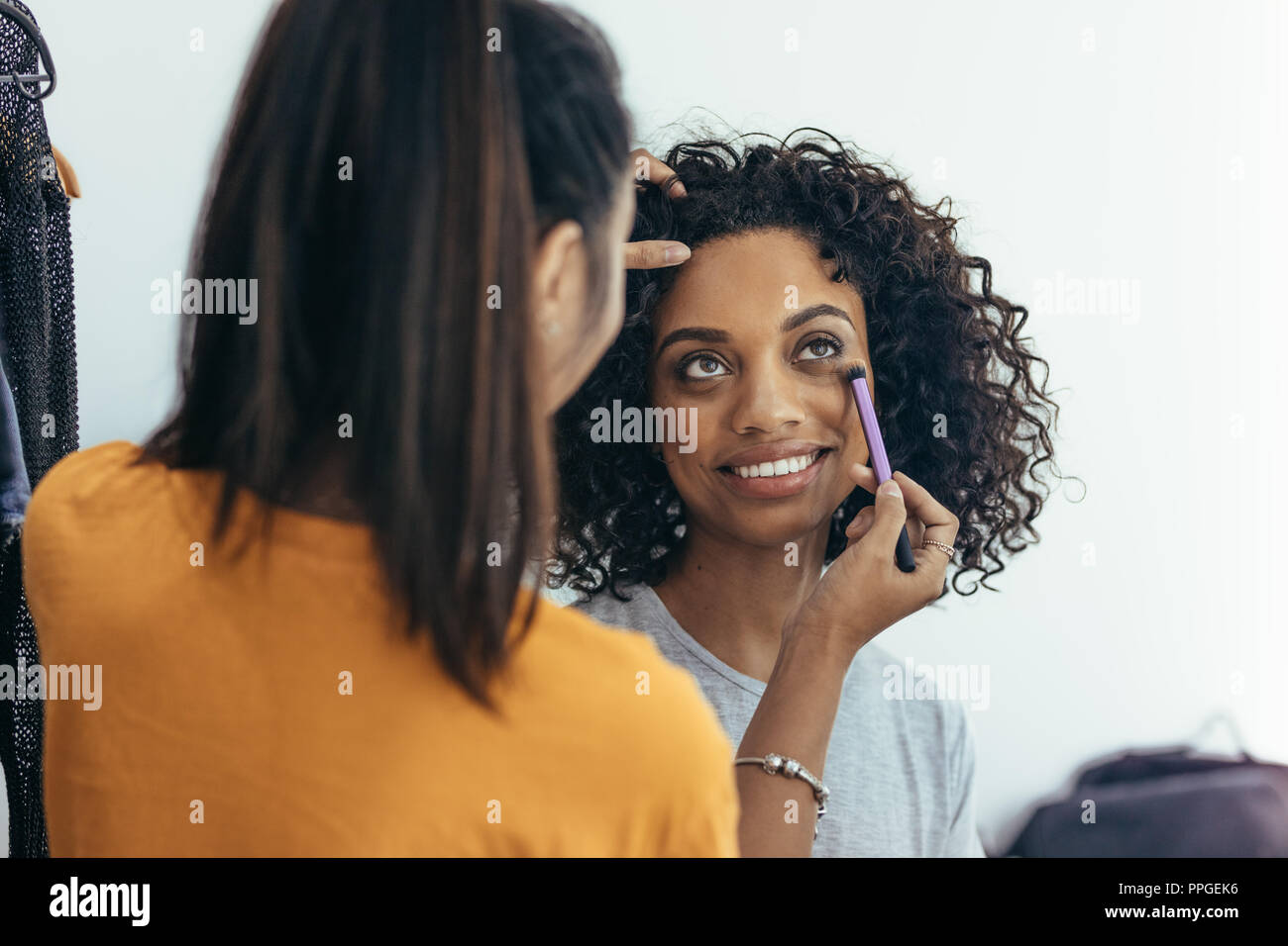 Trucco artisti ombreggiatura sotto gli occhi per rimuovere i cerchi scuri. Il modello in fase di trucco ottenere pronto per il servizio fotografico. Foto Stock