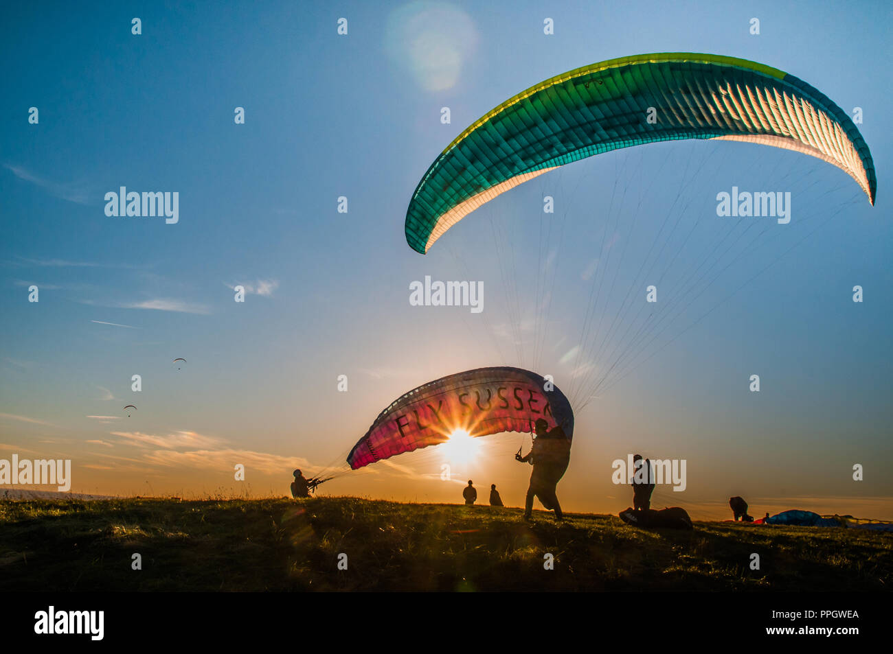 Beachy Head, Eastbourne, East Sussex, Regno Unito..25 settembre 2018..Paragliders sul South Downs mentre il sole tramonta rendono interessanti le silhouette. Foto Stock