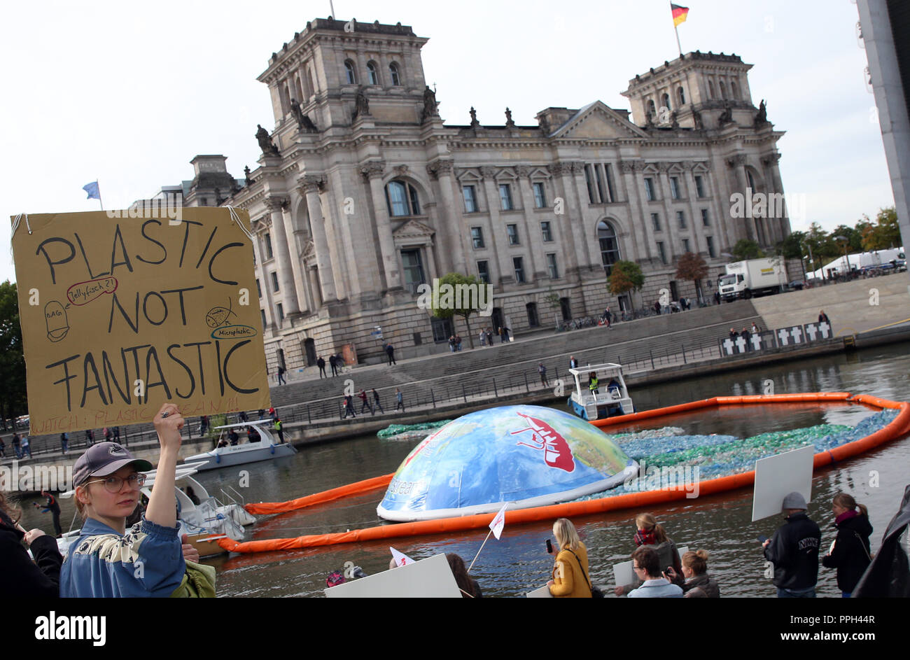 26 settembre 2018, Berlin: un dimostratore sorregge un poster con la scritta 'plastici non fantastico' sulla Sprea di fronte al Reichstag. Lei prende parte alla manifestazione '#GoodbyePlasticBottles' contro i rifiuti plastici, durante la quale un 300 metri quadrati tappetino in plastica è stato steso sul fiume. Foto: Wolfgang Kumm/dpa Foto Stock