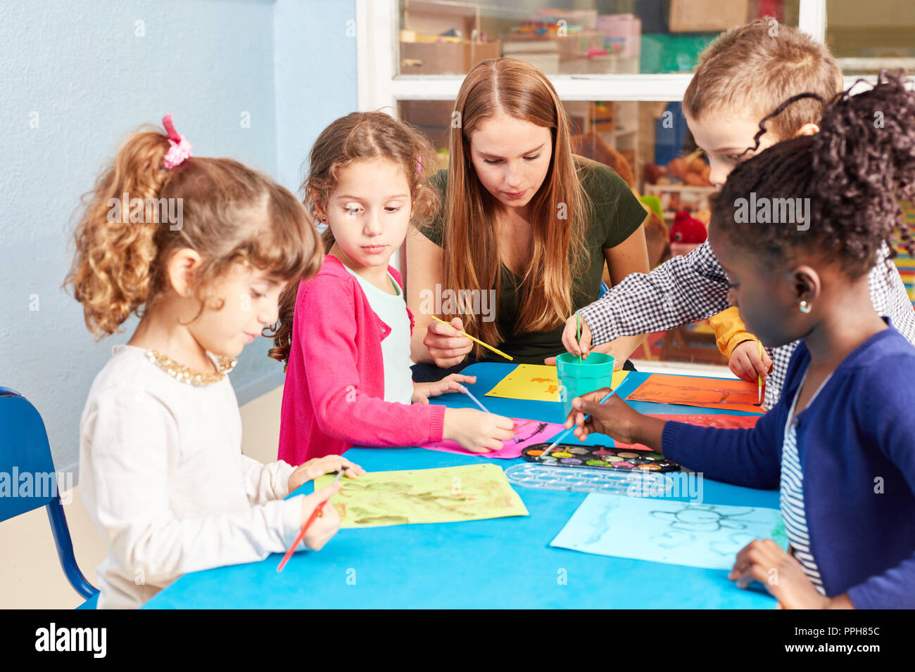 Gruppo di ragazzi di vernici con acquarello e spazzola in classe d'arte alla scuola elementare Foto Stock