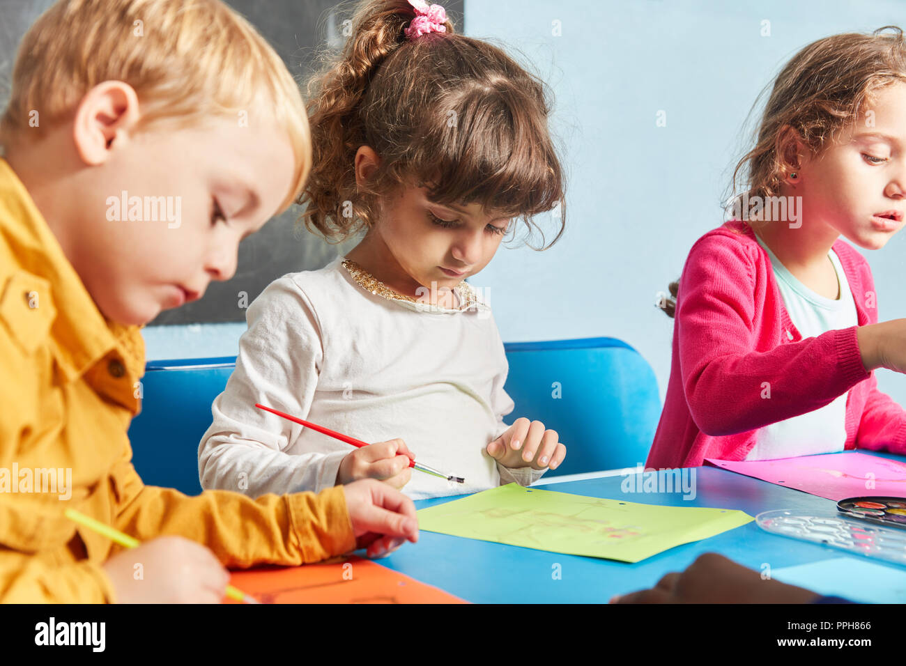 I bambini la vernice insieme con acquarello e spazzola nel corso di disegno nella scuola materna Foto Stock