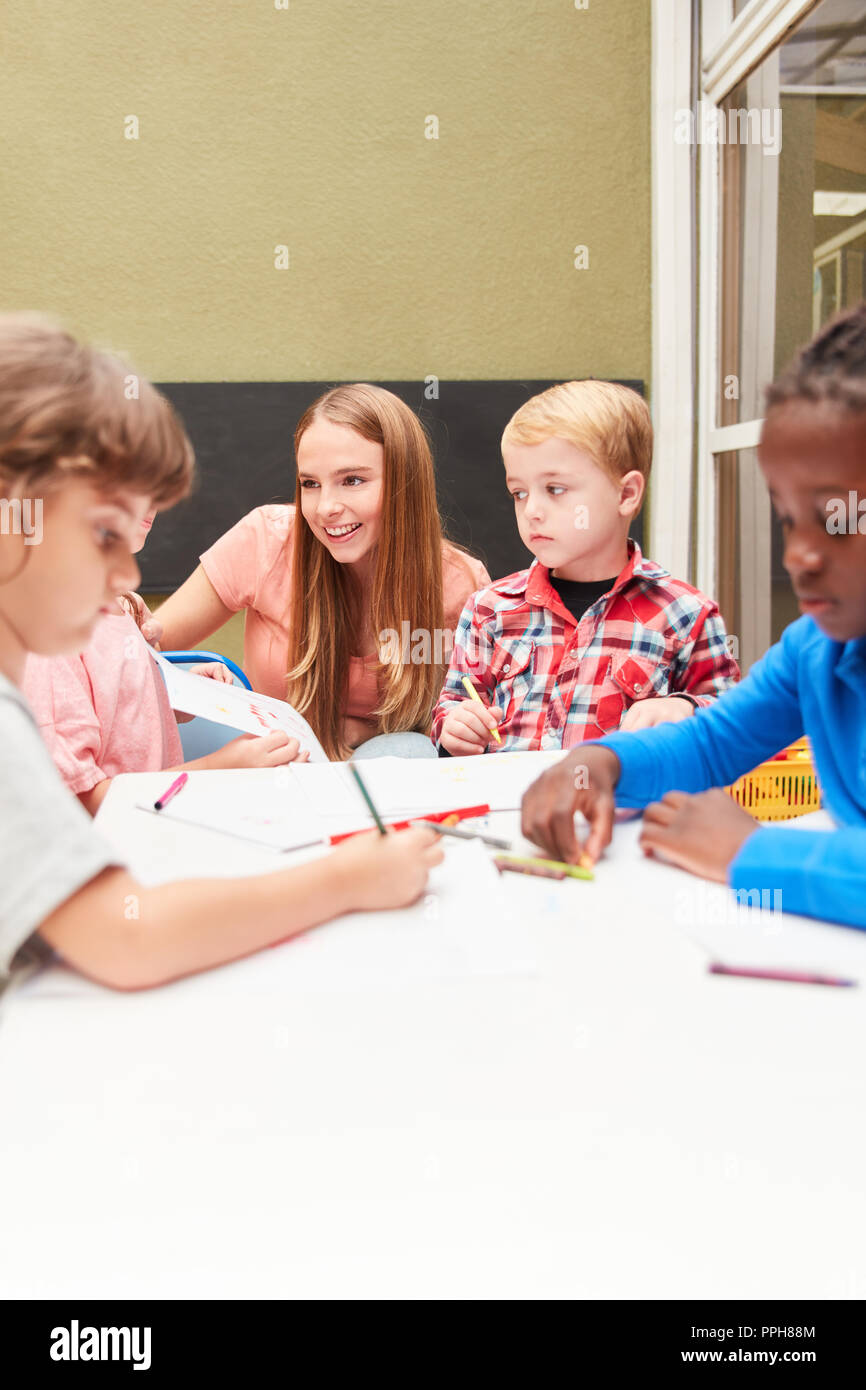 Un gruppo di bambini e insegnanti sono la pittura nella classe di disegno in una scuola materna o asilo nido Foto Stock