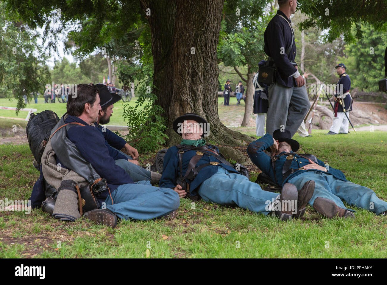Unione dei soldati in riposo sotto un albero durante una guerra civile americana rievocazione storica in Central Park Huntington Beach, California, Stati Uniti d'America Foto Stock