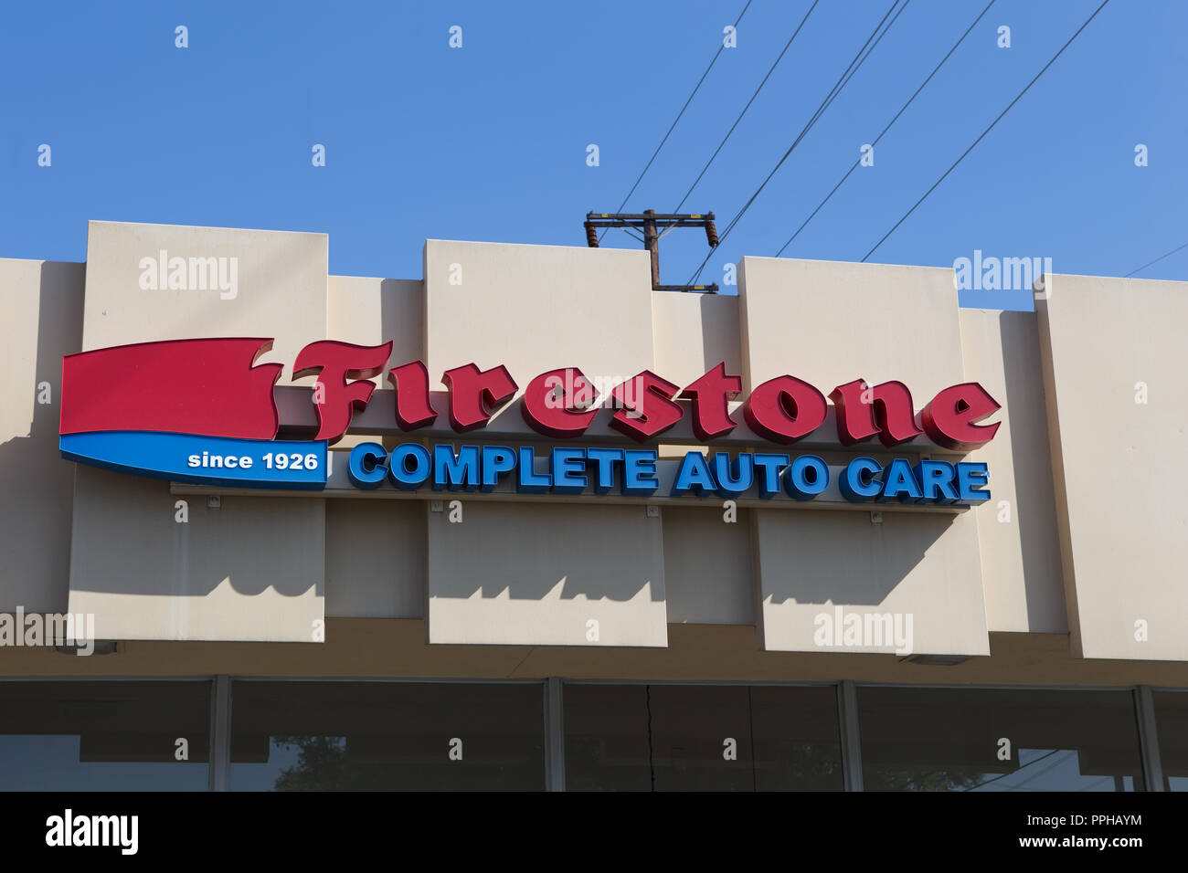 Firestone auto complete care center segno sulla parte esterna dell'edificio in arancione California USA Foto Stock