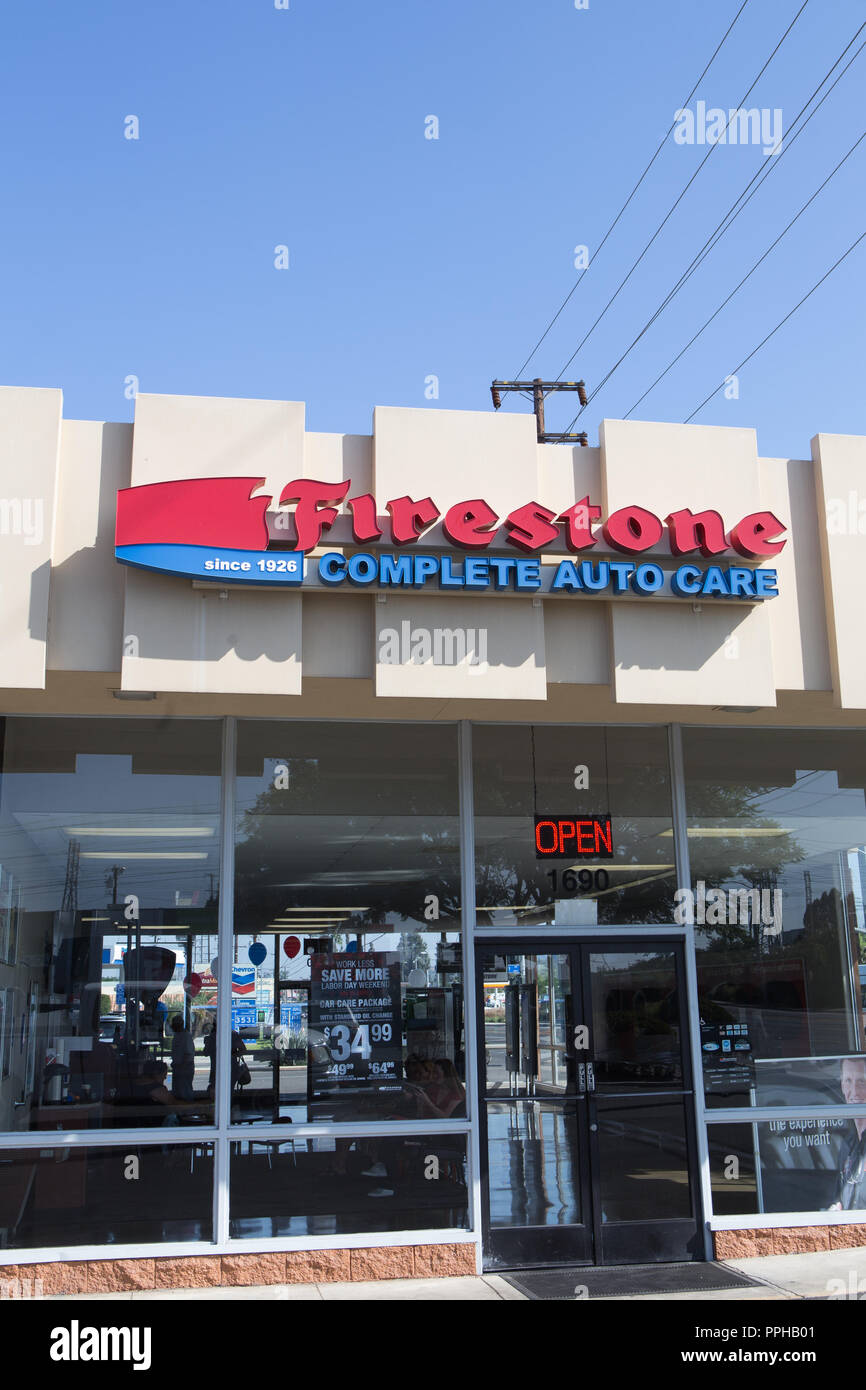 Firestone auto complete care center segno sulla parte esterna dell'edificio in arancione California USA Foto Stock