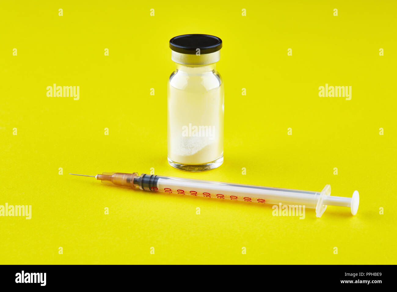 Piccola bottiglia sigillata con la medicina e la siringa su sfondo giallo. Foto Stock