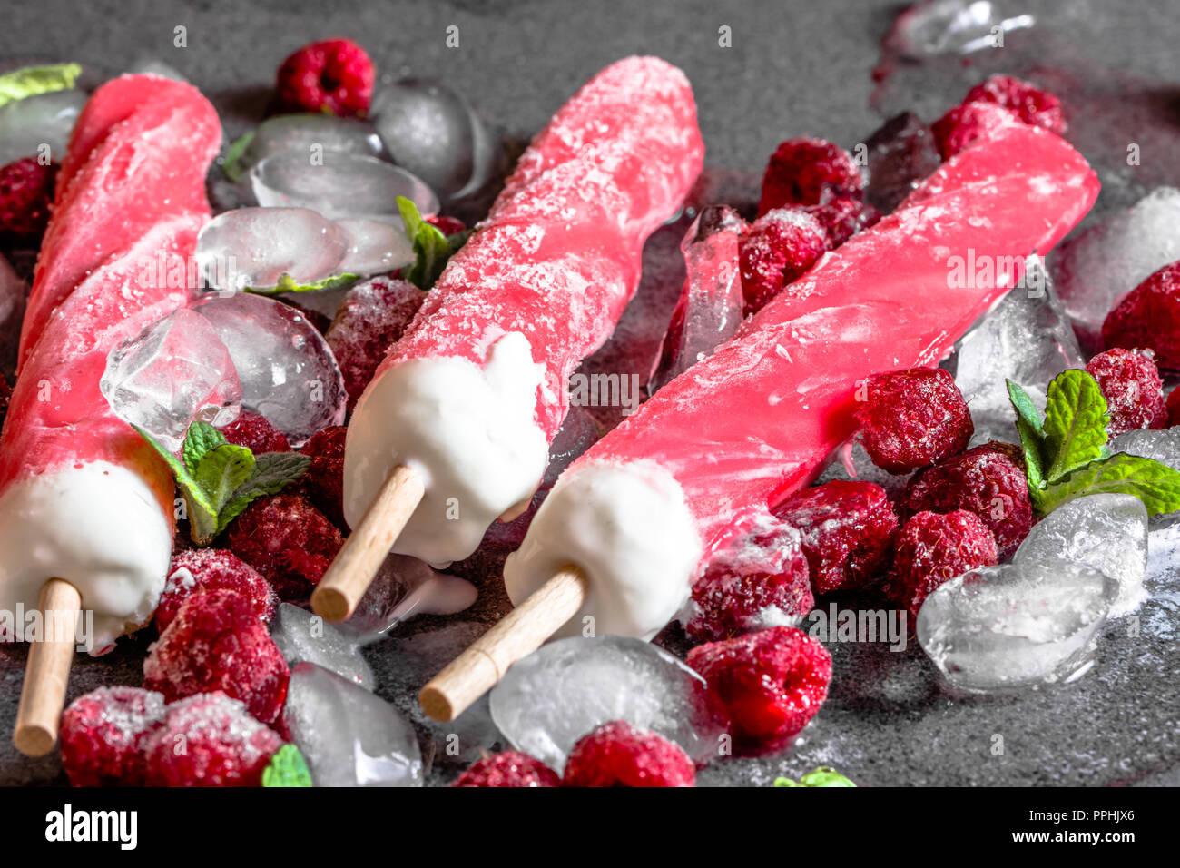 Lampone popsicles su ghiaccio con frutti congelati sorbetto, dolce ristoro estivo Foto Stock