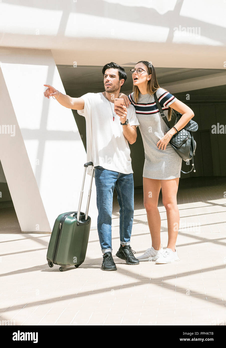 Una giovane coppia viaggiano insieme e cercando il senso utilizzando un GPS su un telefono cellulare smart device Foto Stock