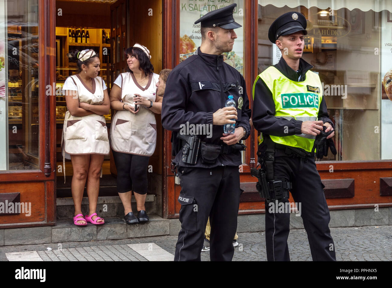 Uniforme della Repubblica ceca gli agenti di polizia e due saleswomen al di fuori del negozio, Praga, Repubblica Ceca Foto Stock