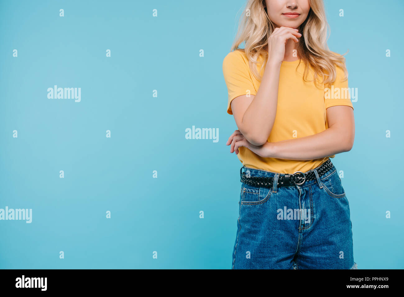 Immagine ritagliata della ragazza mento di appoggio sul lato isolato su blu Foto Stock