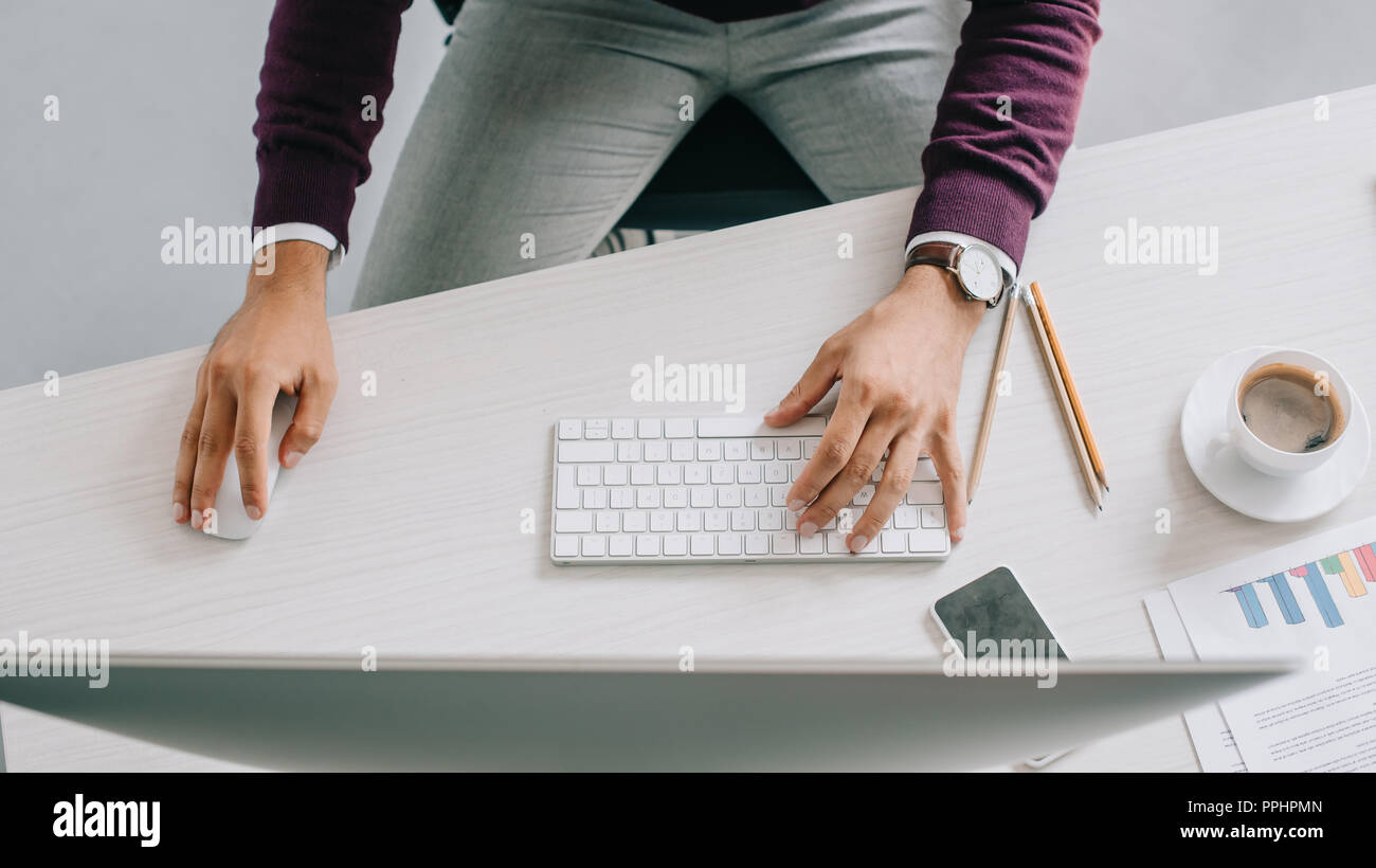 Immagine ritagliata di designer che lavora a tavola col computer in ufficio Foto Stock