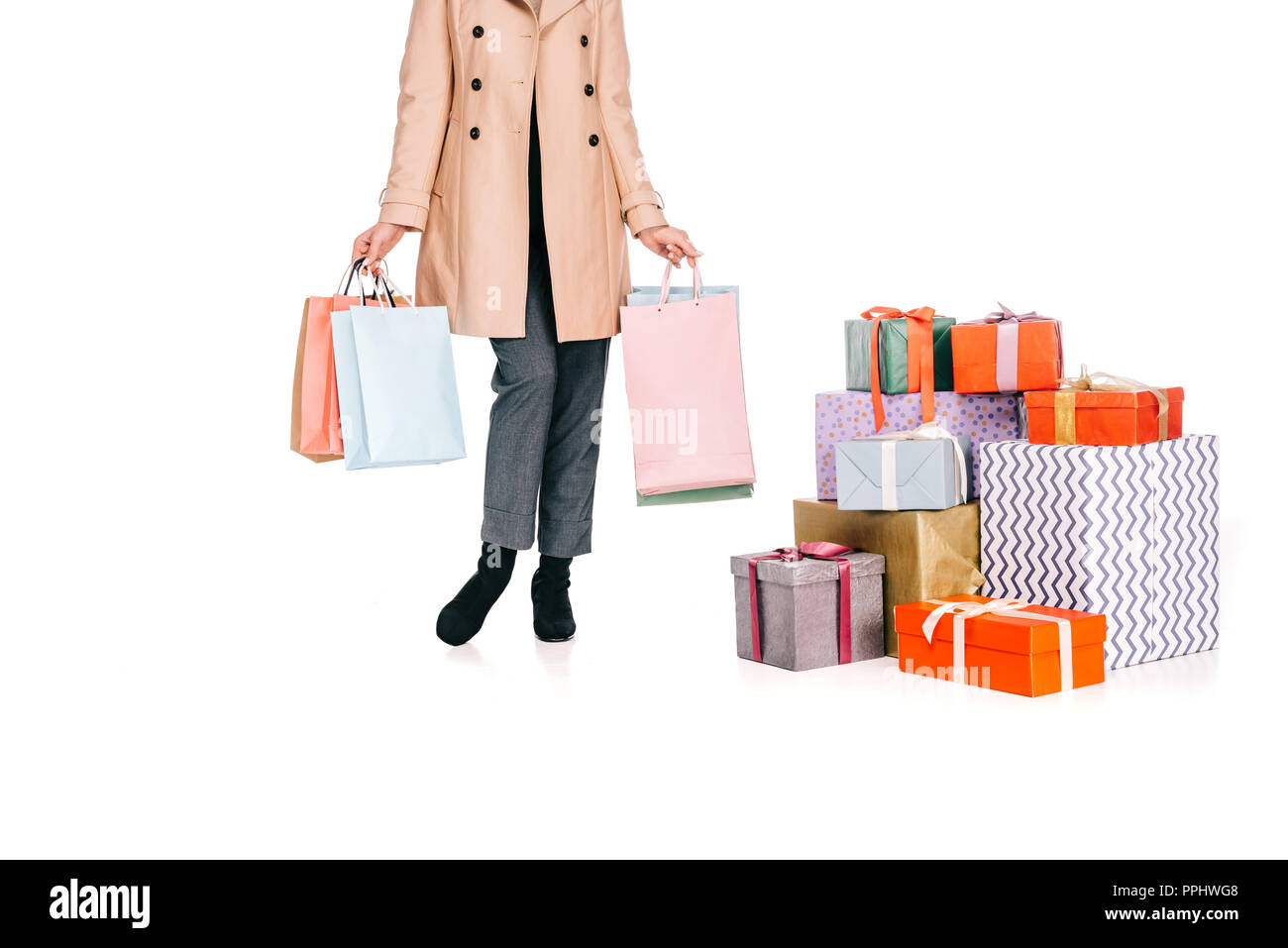 Ritagliato colpo di donna azienda borse per lo shopping e di stare vicino a confezioni regalo isolato su bianco Foto Stock