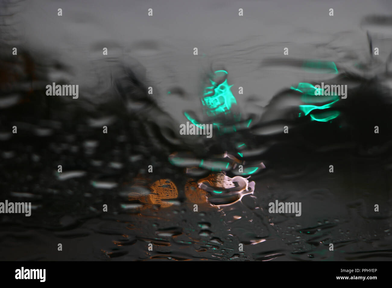 Colori attraverso un parabrezza bagnato in un giorno di pioggia Foto Stock