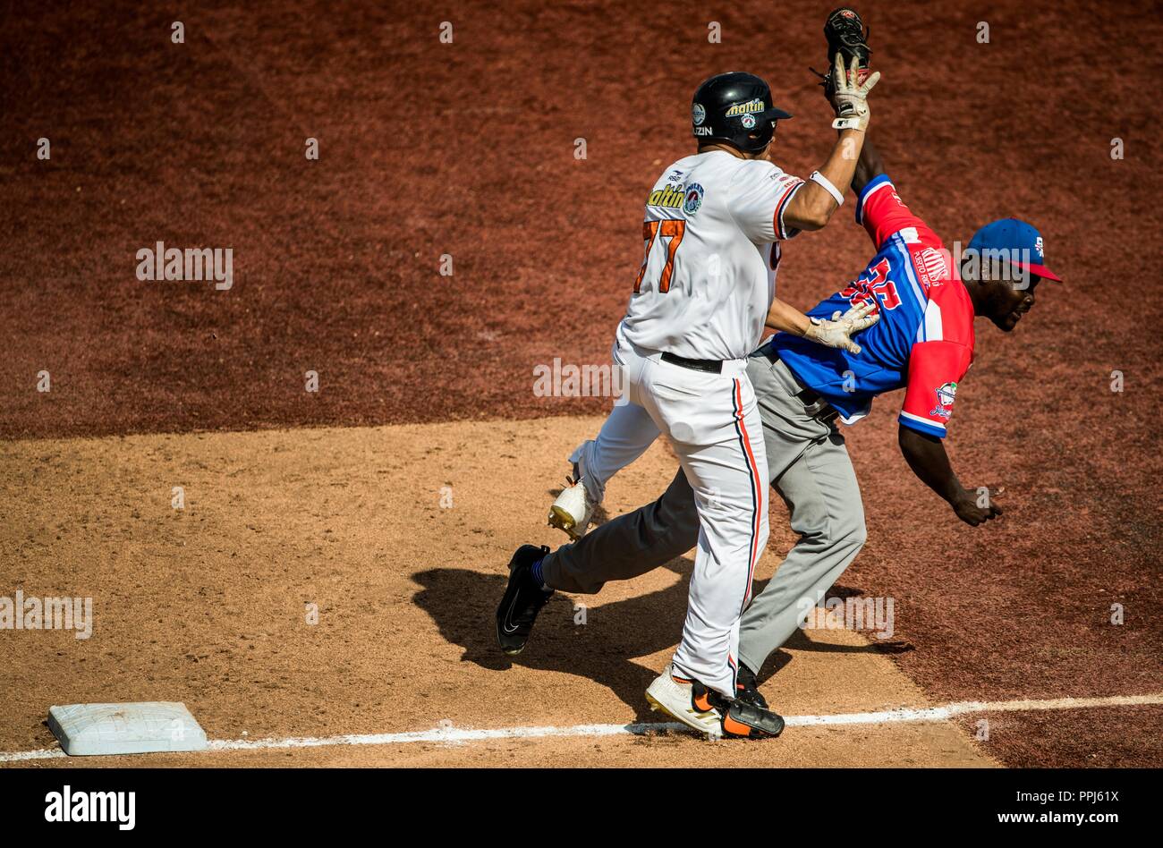 Rene Reyes de Venezuela choca con el lanciatore David Richardson de Puerto Rico en la primera base . . Partido de beisbol de la Serie del Caribe con e Foto Stock