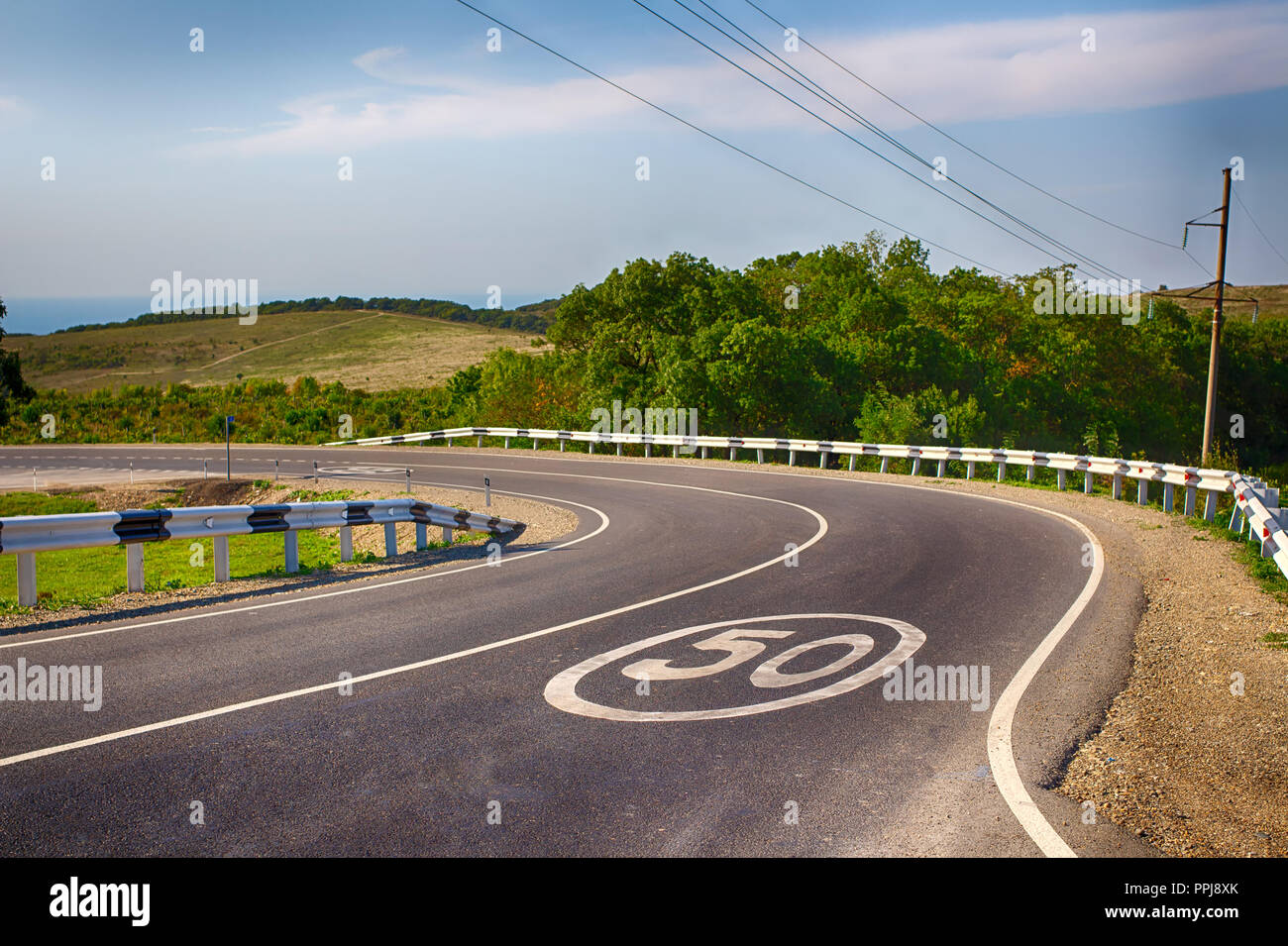 Un pericoloso girare in campagna. Il limite di velocità è di 50 km/h. Circolazione a destra. Foto Stock