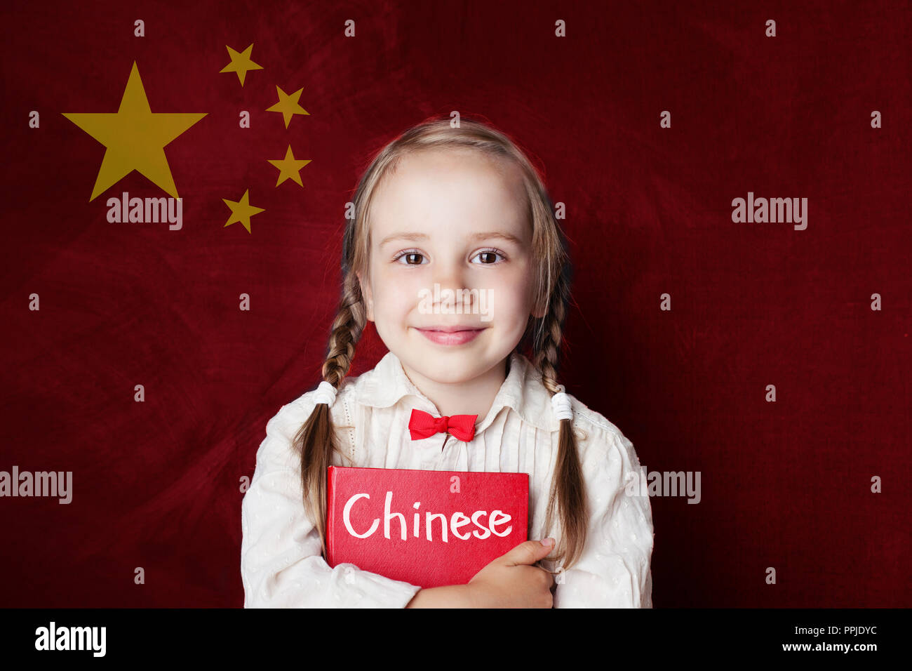 Concetto cinese. Bambina studente con libro contro la bandiera cinese sfondo. Imparare la lingua Foto Stock