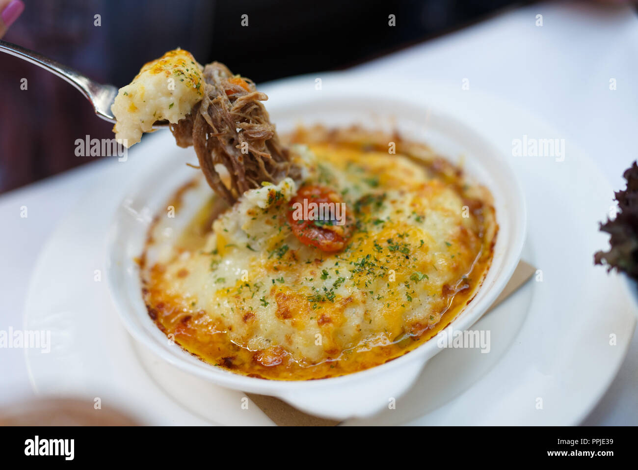 Chiudere il cibo fotografia italiana di fantasia tirata di manzo con formaggio piatto Foto Stock