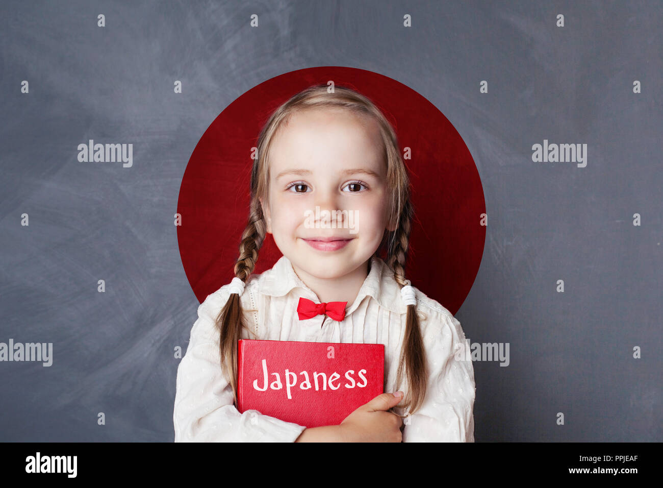 Felice bambino intelligente ragazza con libro sulla bandiera del Giappone sfondo. Apprendimento della lingua giapponese Foto Stock