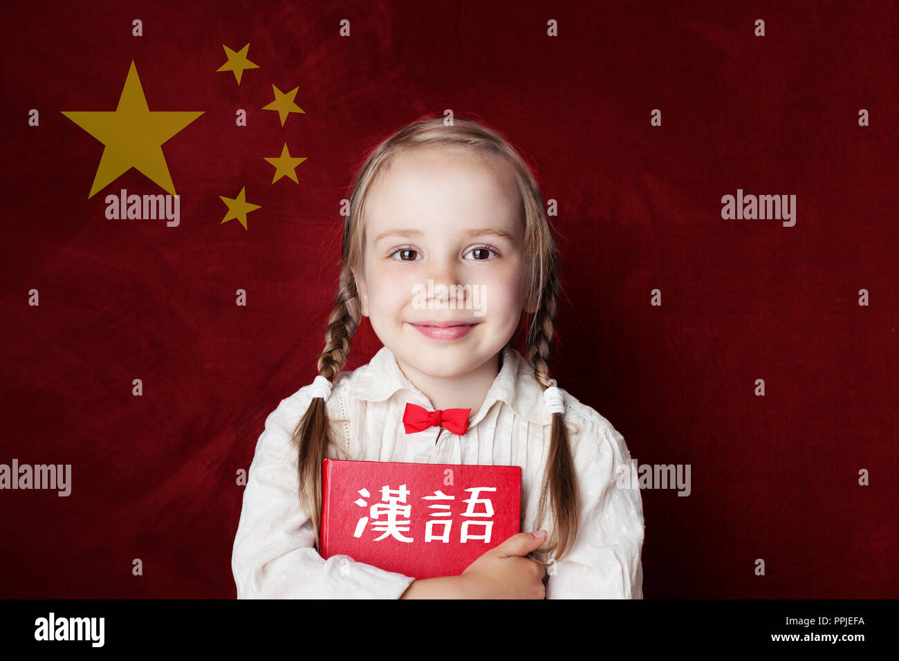 Imparare la lingua cinese. Smart bambino studente sulla bandiera cinese sfondo Foto Stock