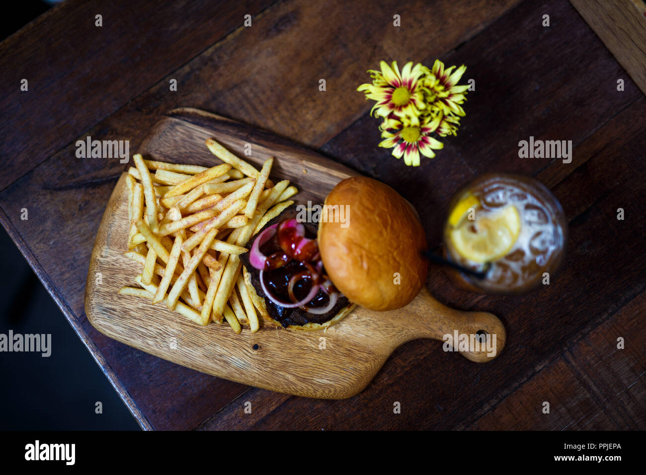 Immagine ravvicinata di gourmet hamburger e patatine serviti sul vassoio in legno Foto Stock