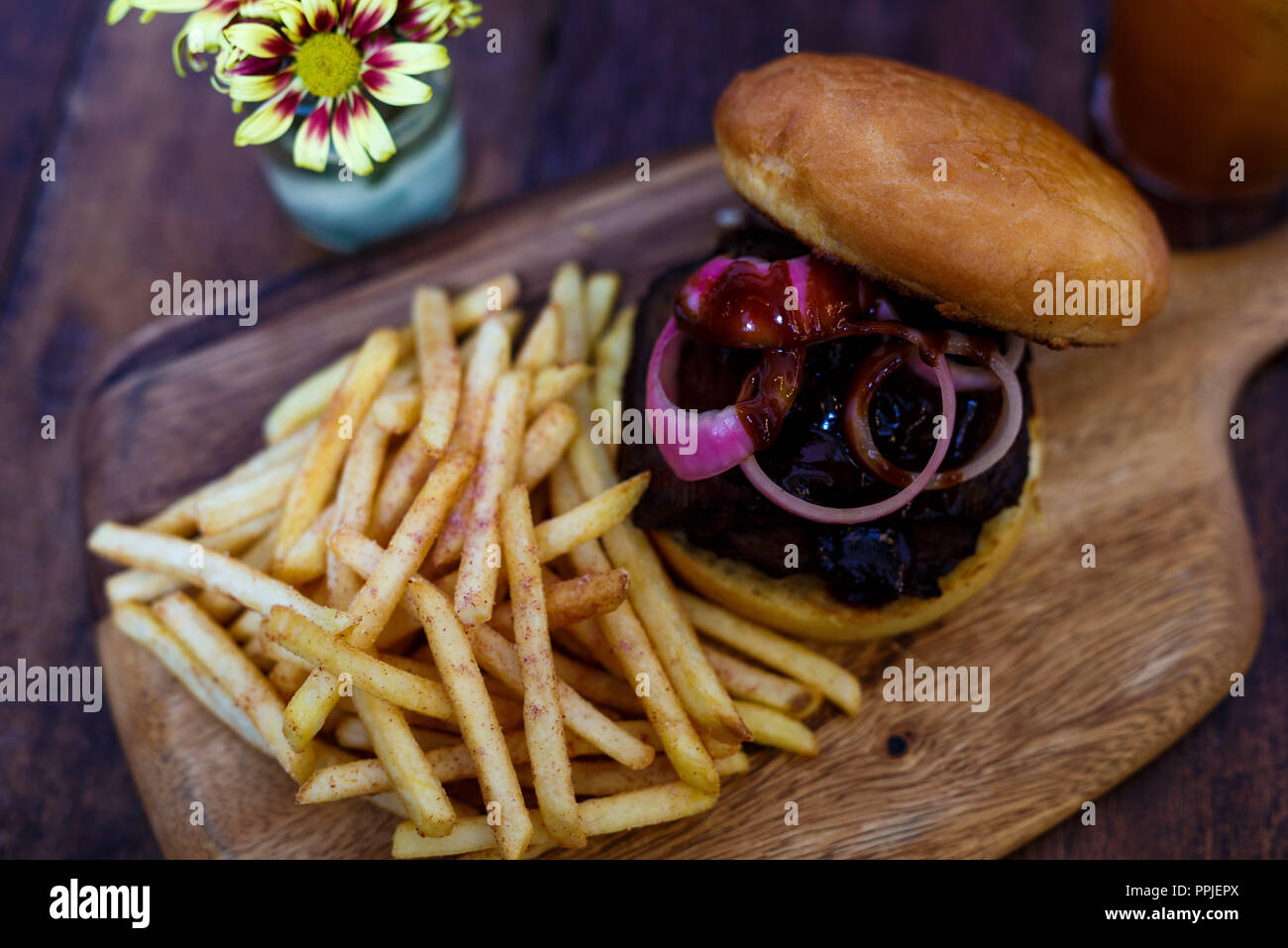 Immagine ravvicinata di gourmet hamburger e patatine serviti sul vassoio in legno Foto Stock