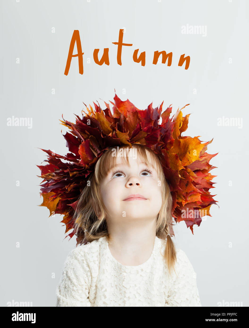 Bambino carina ragazza con foglie di autunno guardando in alto, concetto di autunno Foto Stock