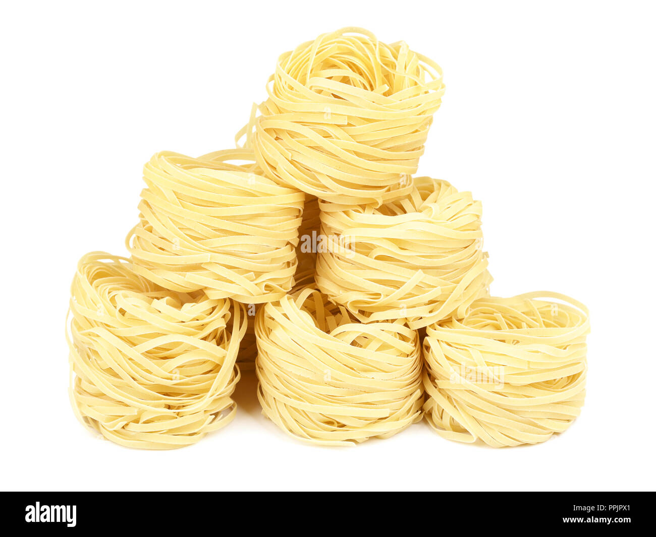 Pasta cruda nido di tagliatelle, isolato su bianco Foto Stock