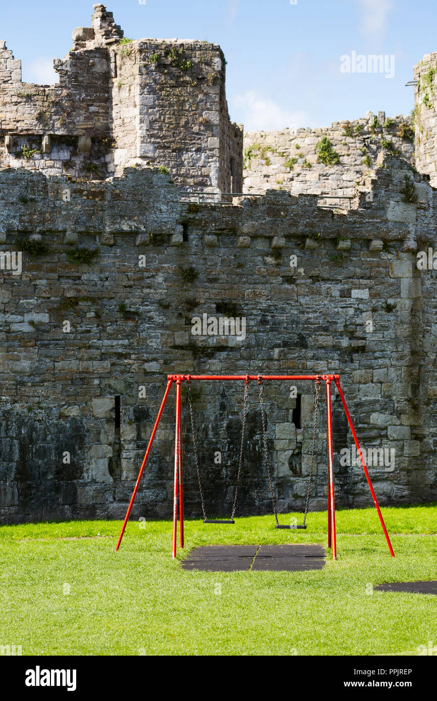 Beaumaris Castle in Beaumaris con altalena per bambini parco di fronte. Anglesey, Galles del Nord Foto Stock