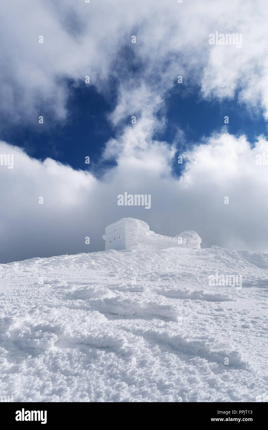 Paesaggio invernale con una bella texture della neve. Il vecchio osservatorio sulla cima della montagna. Giornata di sole. Carpazi, Ucraina, Europa Foto Stock