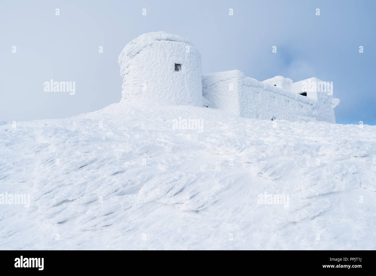 Paesaggio invernale con una bella texture della neve. Il vecchio osservatorio sulla cima della montagna. Giorno nuvoloso. Carpazi, Ucraina, Europa Foto Stock