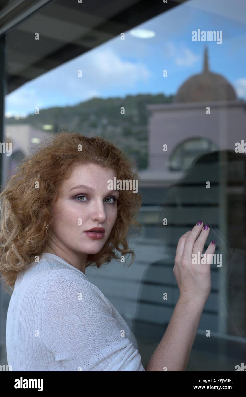 Donna contro la finestra di vetro Foto Stock