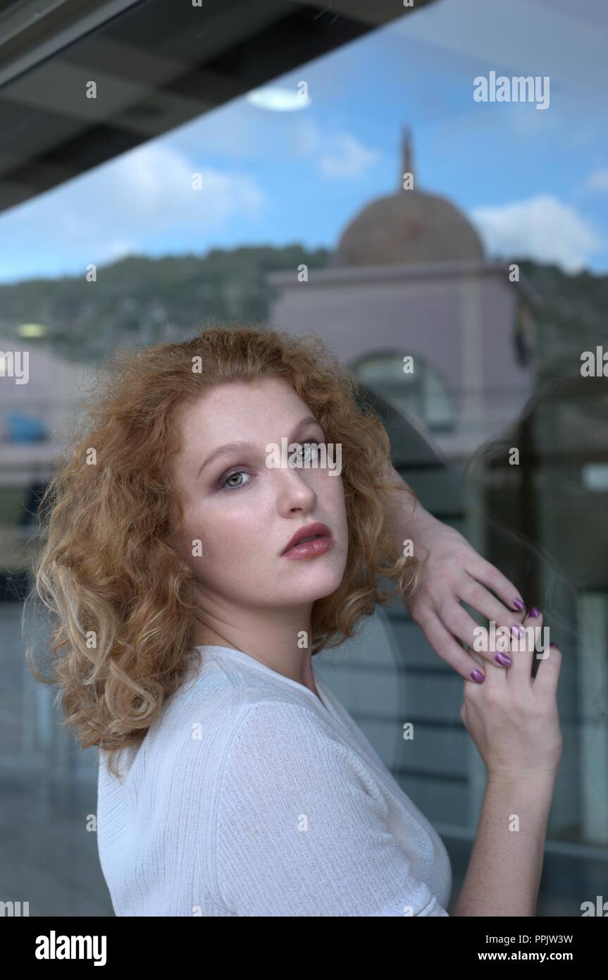 Donna contro la finestra di vetro Foto Stock