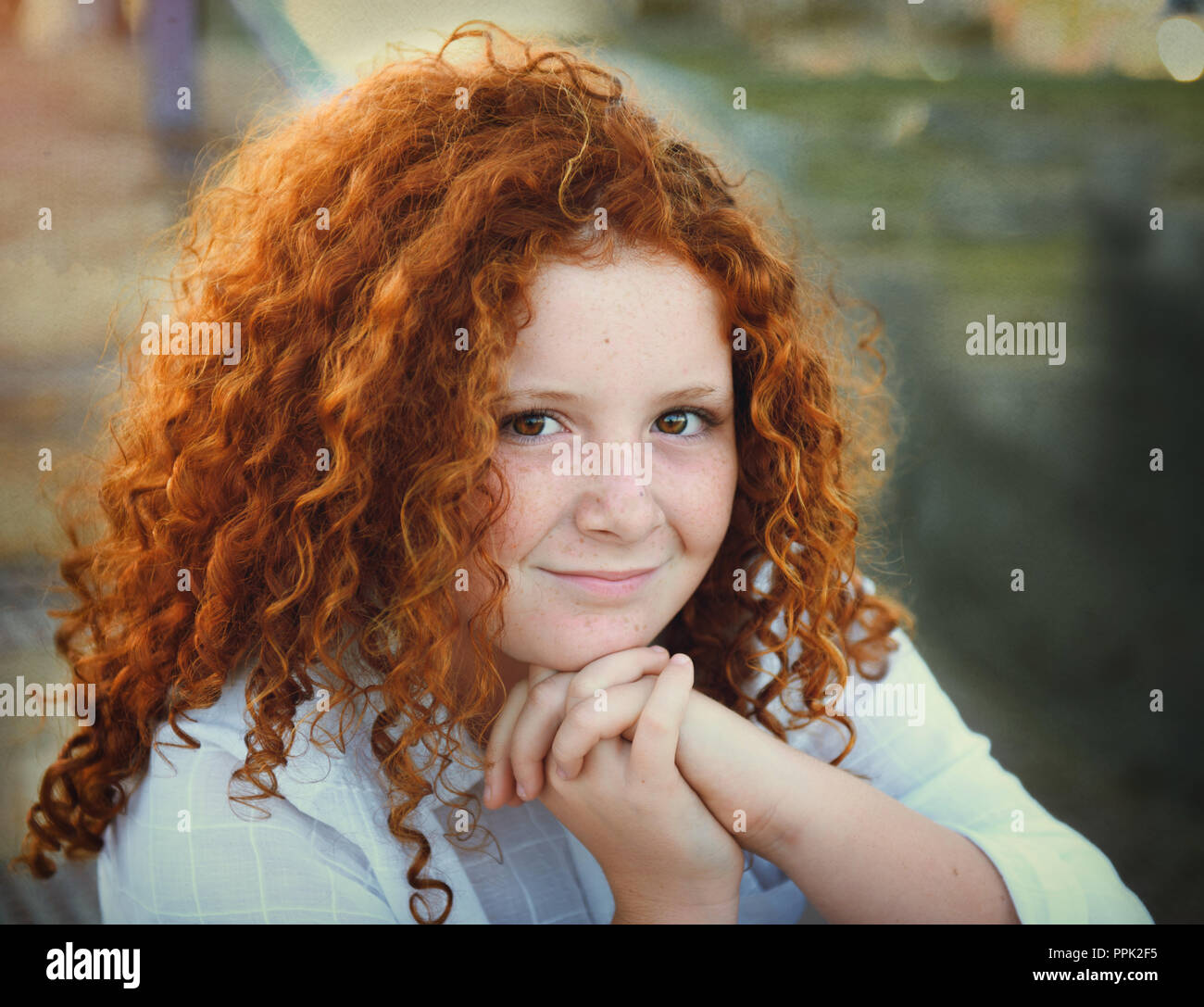 Pretty redhead giovane ragazza con i capelli ricci ritratto all'aperto Foto Stock