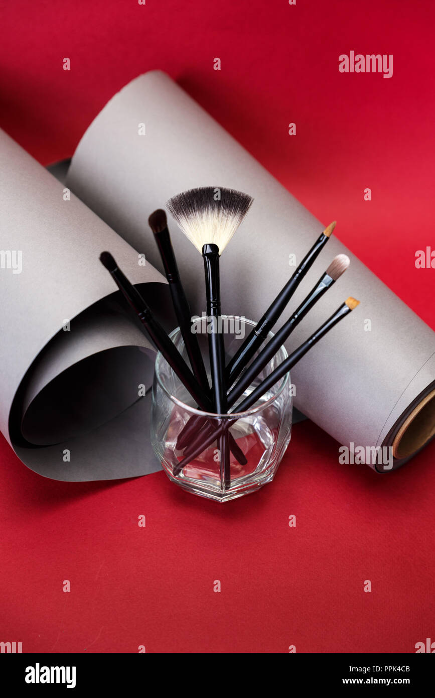 Chiudere la foto del prodotto bellezza / spazzole cosmetiche su sfondo rosso in vetro Foto Stock