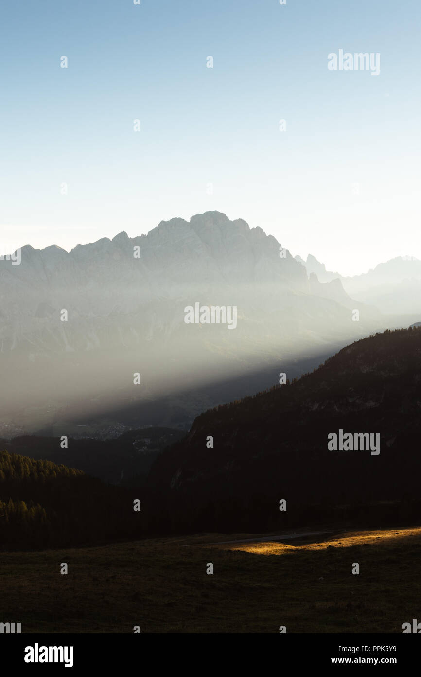 Primo raggio di luce su una nebbiosa mattina nelle Dolomiti Italia Foto Stock