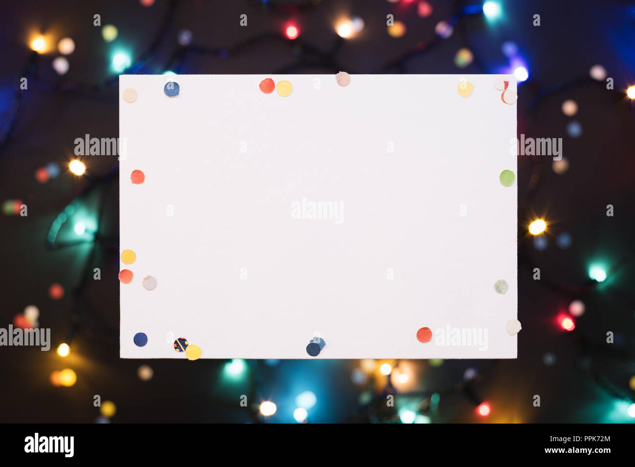 Sfondo di natale con decorazioni e foglio bianco per il testo di festa. Vista superiore, copia dello spazio. Anno nuovo concetto con coriandoli e incandescente garland Foto Stock