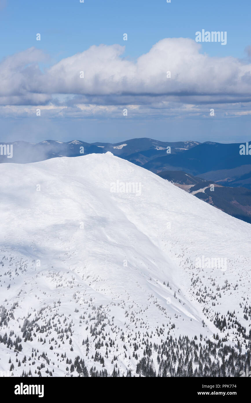Montagne innevate in inverno. Tempo soleggiato con belle nuvole. Vista della cresta Foto Stock