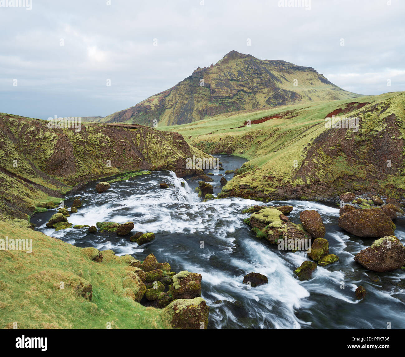 Belle cascate sul fiume Skoga, Islanda. Gorge sopra la cascata Skogafoss. Incredibile in natura. Erba verde e Moss. Vista verso la cima della montagna Foto Stock