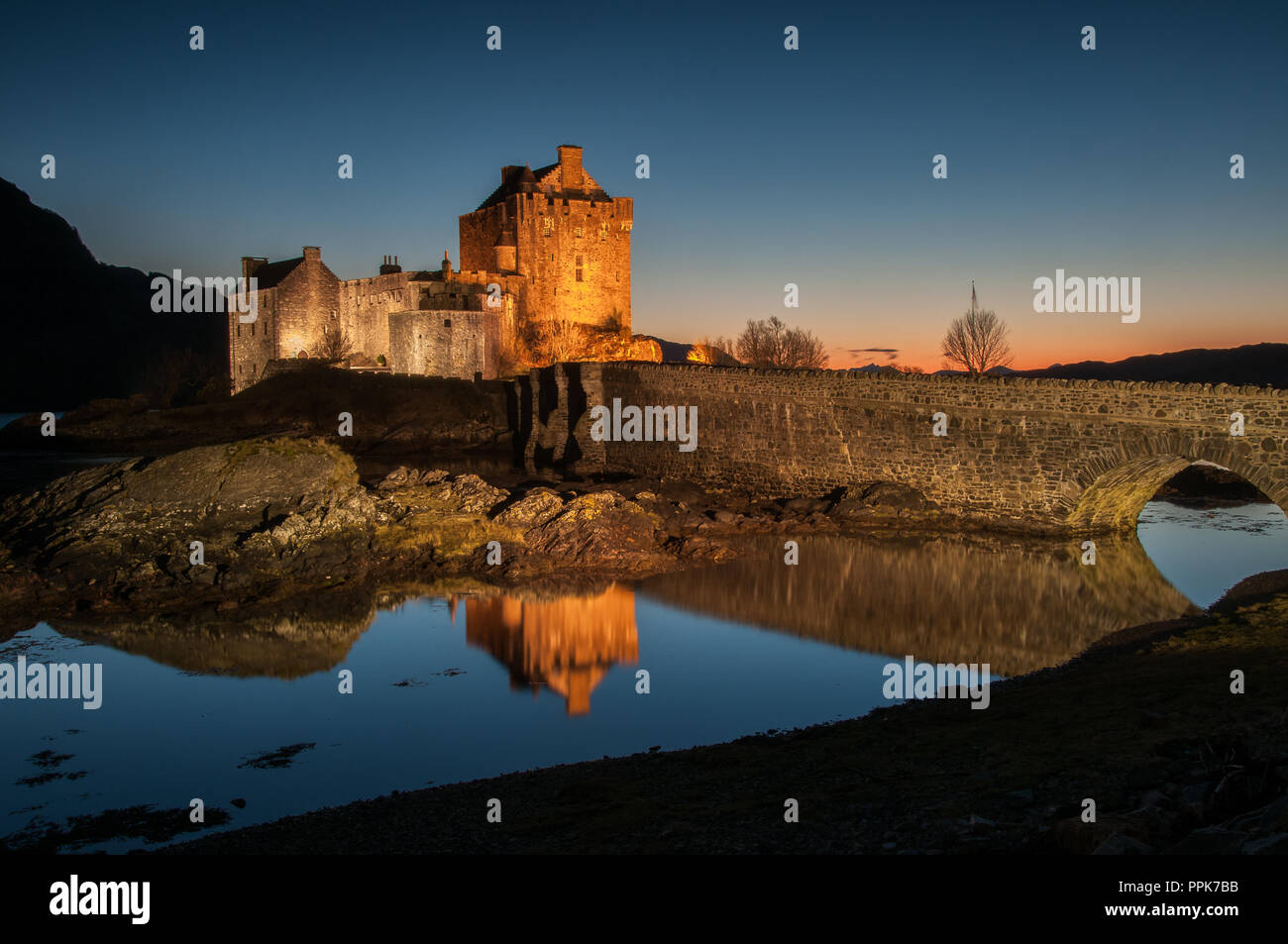 Il vecchio castello del XIII secolo di Eilean Donan seduto su una piccola isola nel Loch Alsh al tramonto Foto Stock