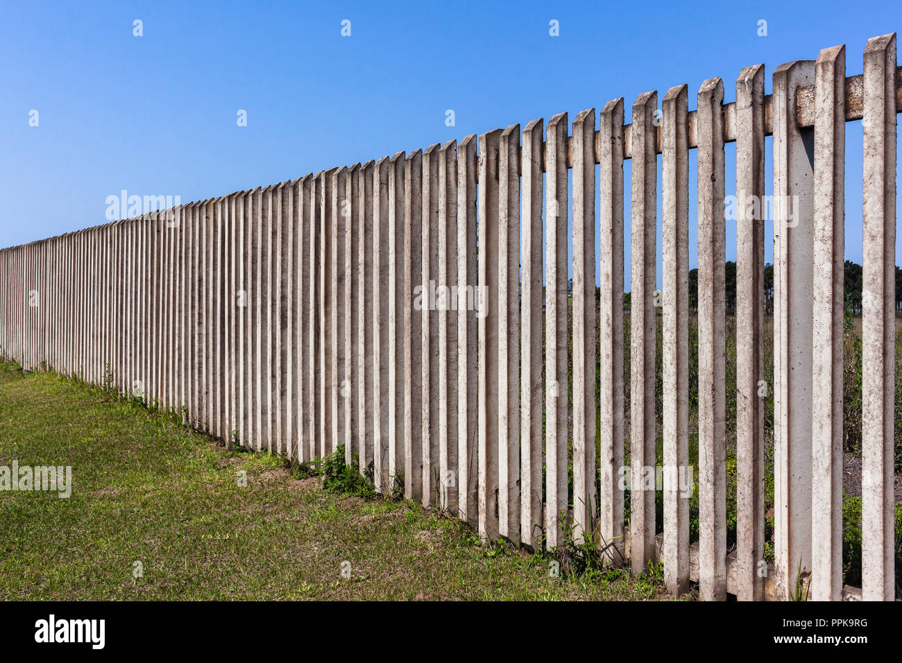 Recinzione di close-up verticale quadrato in calcestruzzo pali con visual  fessure lungo la proprietà privata campagna Foto stock - Alamy