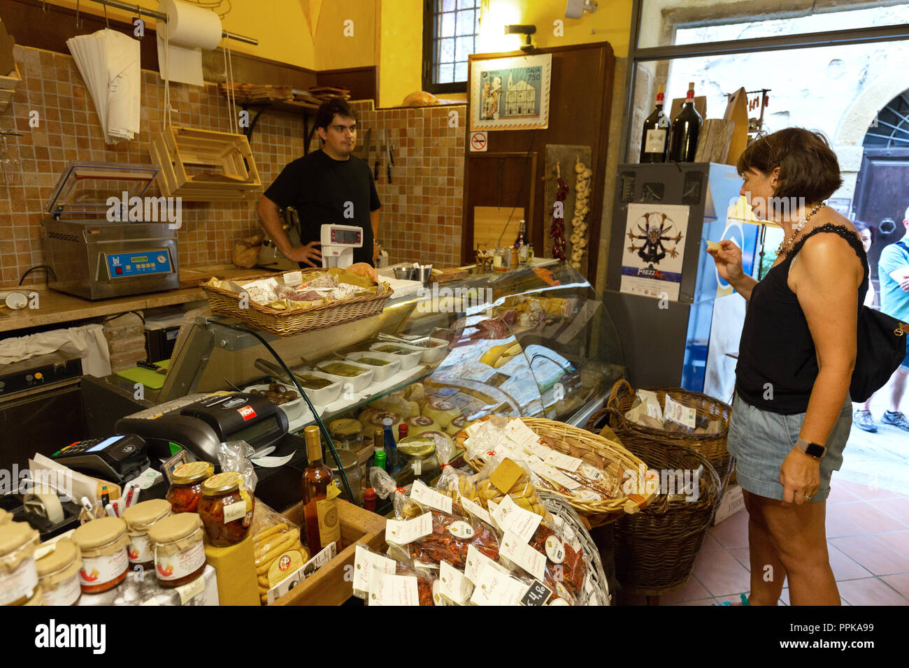 Donna shopping per alimenti in un cibo italiano shop, Montalcino, Toscana Italia Europa Foto Stock