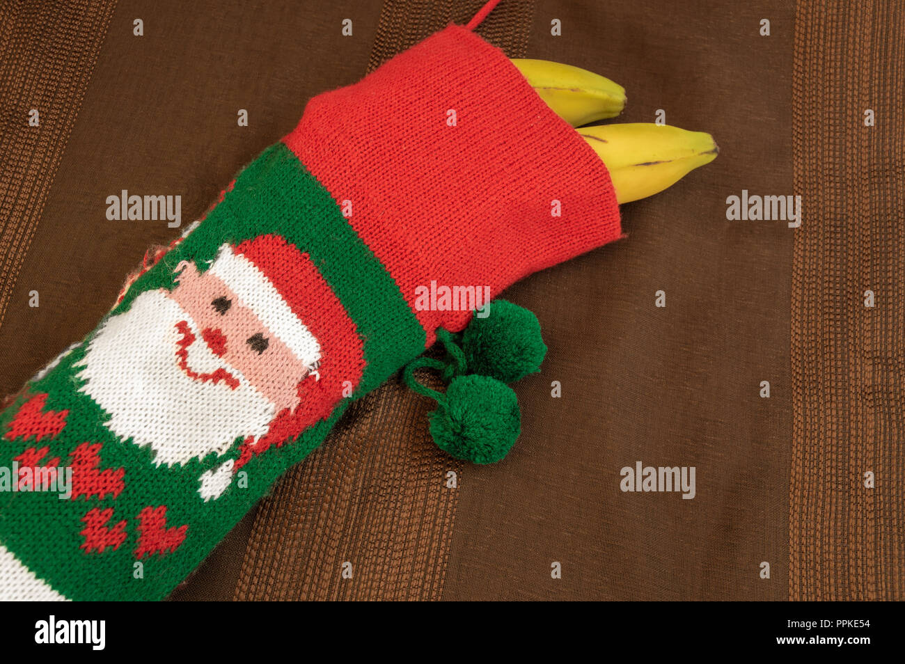 Colorato calza di Natale con il disegno di Babbo Natale riempito con le  banane. Concetto di regalo per il bambino che è stato male, regalo sano,  improvvisare un presente Foto stock -
