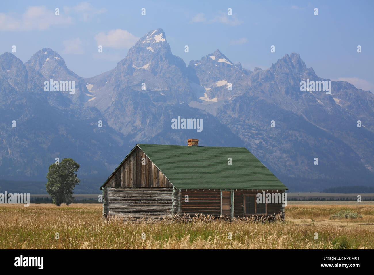 Storica azienda rustico edificio su Prairie con spettacolari montagne sullo sfondo Foto Stock