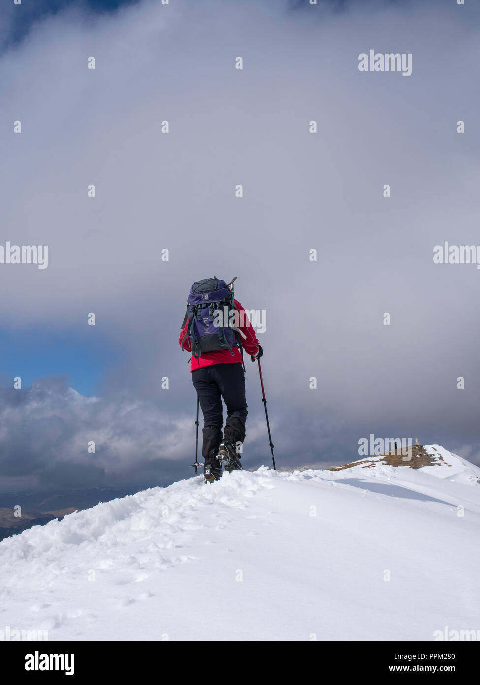 Una femmina di walker avvicinarsi al vertice di Ben Vorlich, vicino a Loch Earn, su un croccante di inverni di giorno in Scozia Foto Stock